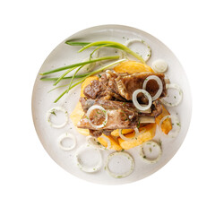 Isolated plate of cooked lamb ribs with potatoes on white background