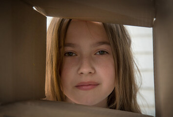A teenage girl stares intently at the box, her eyes full of interest and incomprehension.