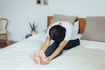 Frau macht Yoga zuhause zur Entspannung auf dem Bett
