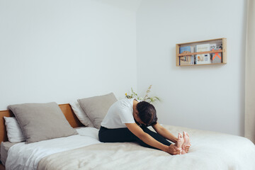 Frau macht Yoga zuhause zur Entspannung auf dem Bett