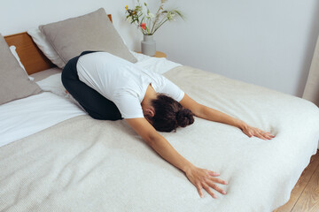 Frau macht Yoga zuhause zur Entspannung auf dem Bett