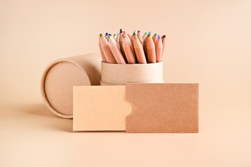 Business card mockup , eco kraft paper and a set of colored pencils on a beige background. Eco...