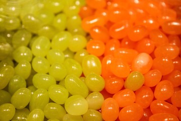 Bunch of green and orange dragees chewing candies
