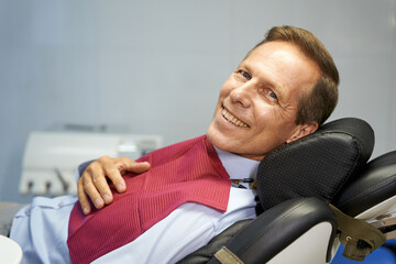 Cheerful man having a dental check-up at clinic