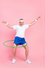 Full length body size photo man keeping hoola hoop training in gym hands over head funny isolated pastel pink color background
