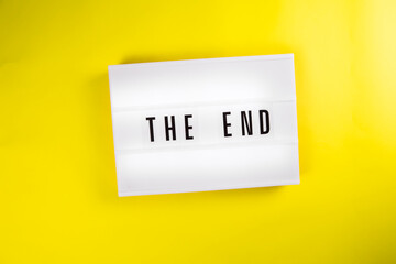 Lightbox with message THE END isolated on yellow background. Concept of finish, closure, end of year, diet, clearance, goal achievement, positive result, end coronavirus disease quarantine outbreak