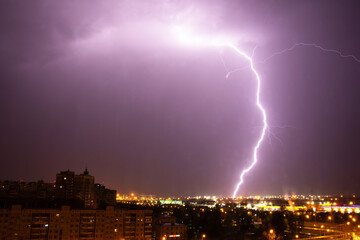Naklejka na ściany i meble Lightning strike the ground in the city at night.