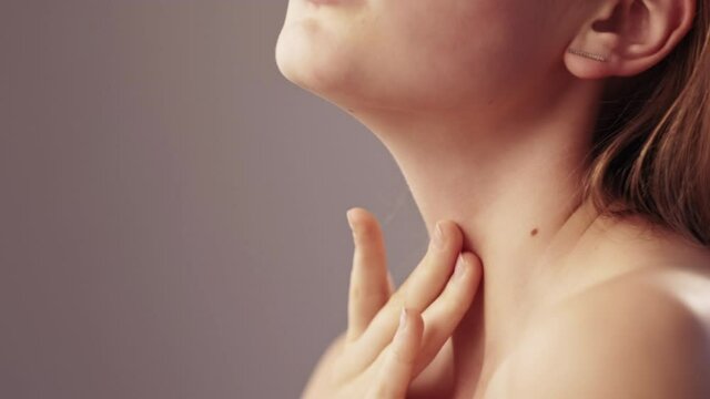 Body care. Sensual woman. Beauty spa. Skincare cosmetic. Delicate treatment. Unrecognizable profile elegant lady tenderly touching face neck zone by hand isolated beige copy space.