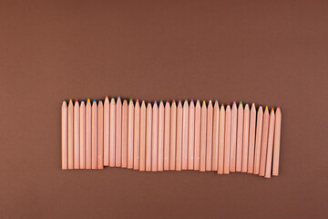 Eco colored pencils made from recycled material. A fence made of wooden pencils. Top view. Free space for text. High quality photo. Banner 
