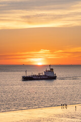 Boat passing by the beach in Vlissingen Holland in sunset