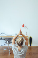 Frau macht Yoga im Homeoffie zur Entspannung und als Ausgleich 