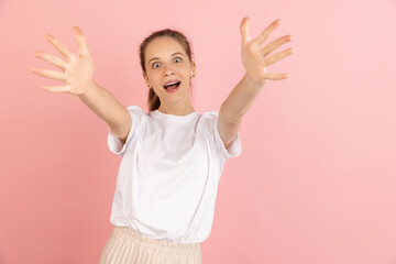 Caucasian young woman's portrait isolated over pink studio background with copyspace