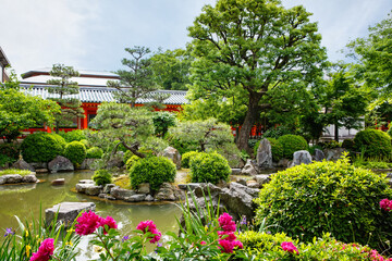 Japanese garden in Fushimi Inari Taisha Shrine in Kyoto, Japan with beautiful red gates. Blossoming...