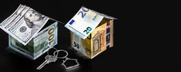 The concept of mortgage and rental housing and real estate. Mortgage credit lending. Metal keychain in the shape of a house with a key. Houses made of dollar and euro bills. Banner format.