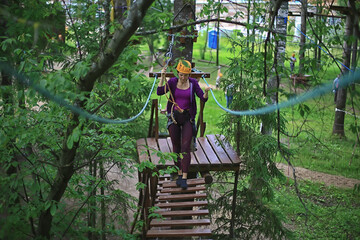 extreme vacation, girl in a yellow helmet rope park active holidays in the forest