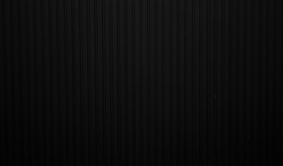 Black corrugated iron sheet used as a facade of a warehouse or factory. Texture of a seamless...