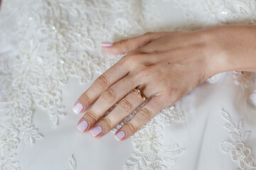 Bride's hand touching details of her wedding dress