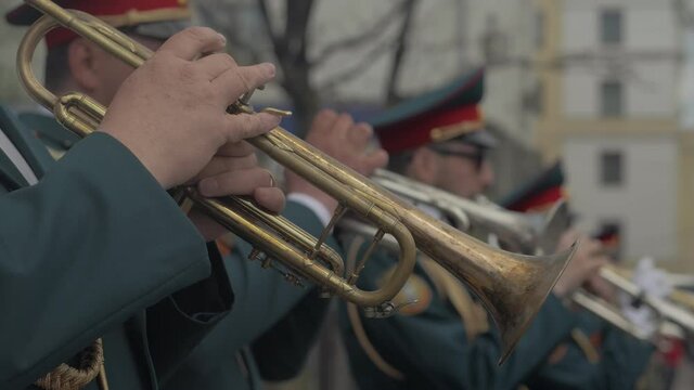 A military brass band plays a musical instrument during a city holiday