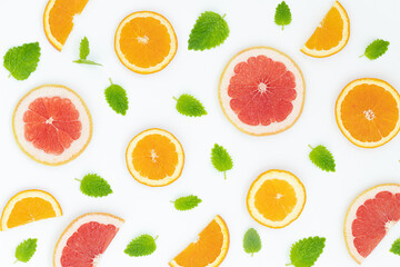 Summer bright background with oranges, grapefruites and green leaves on the gray surface