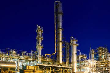 Fototapeta premium Chemical plant, petrochemical factory at night. Petro chemical power industry refinery enterprise of methanol. Late night industrial landscape background with copyspace.