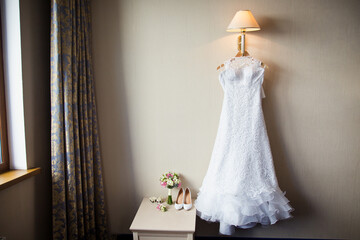 Wedding dress in a room. Bride's morning preparation