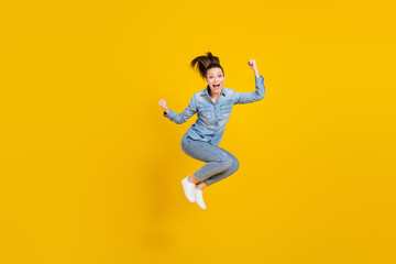 Fototapeta na wymiar Full length body size photo young pretty girl jumping up gesturing like winner isolated bright yellow color background
