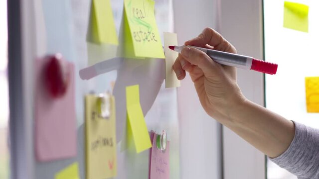 Hand writes down note post on sticker. Brainstorm. Business idea concept. 4K.