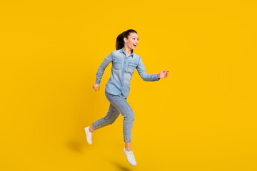 Fototapeta na wymiar Full length body size smiling girl jumping up running on sale isolated vivid yellow color background