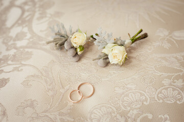 delicate boutonnieres with little white roses and brunei and wedding rings 