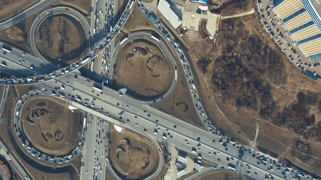 Roundabout with cars, aerial view. Beautiful panorama of the highway in the evening at sunset. Countryside landscape, advanced innovation concept, transport logistics.