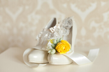 Wedding accessories: Bride's shoes and boutonniere in yellow colors