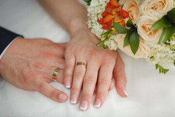 Obraz na płótnie Canvas Hands of bride and groom on a bridal bouquet