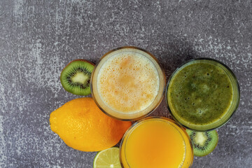Top view of glasses of orange juice and banana kiwi and spinach smoothies