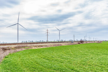 Fototapeta na wymiar Wind turbines generating electricity in a green field. Green power generation concept.