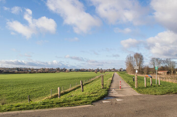 Fototapeta na wymiar biking road on dike near river IJssel in Dutch polder in winter