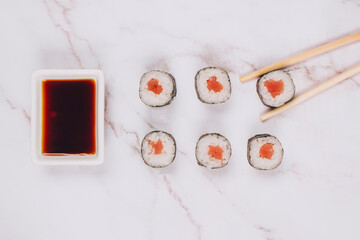 Classic sashimi with salmon or tuna fish, soy sauce and chopsticks on marble table background - maki sushi roll, nori maki, futomaki. Asian food delivery, online order food concept, sushi bar menu