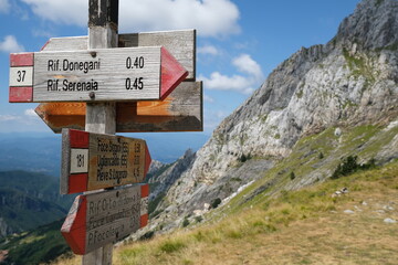 Arrows on a pole indicating the mountain paths of the Apuan Alps.The signs along the route indicate the mountain huts of Serenaia and Donegani. 