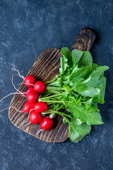 Bundle of fresh organic radish from farm on rustic board