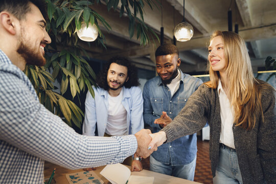 Female office executive shaking hand of new male team member employee