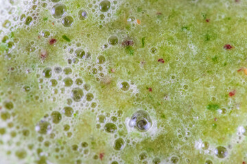 Close-up on the texture of a smoothie in a mug, bubbles of liquid, top view.