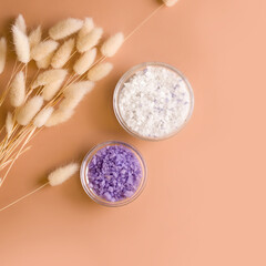 White and purple bath salt on a beige background. View from above. Copy space