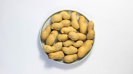 Peanuts in a shell in a saucer on a white background. The legume family.