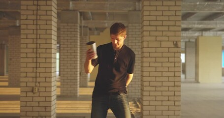 Professional bartender juggles bottles. The bartender is practice in hall at bright sun light. Slow motion