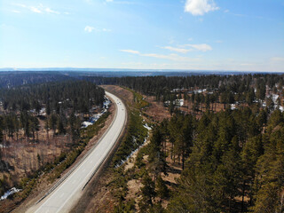 Paved road through the spring forest from the air. created by dji camera. created by dji camera