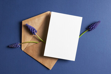 Invitation or greeting card mockup with envelope and spring blue muscari flowers