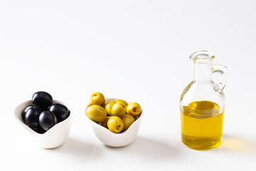 Olive oil  bottle  and black and green olive in bowls on  white background. laqrge image for banner,