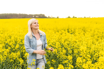 Portrait of young beautiful woman in blooming rapeseed meadow