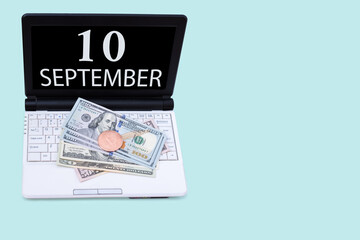 Laptop with the date of 10 september and cryptocurrency Bitcoin, dollars on a blue background. Buy or sell cryptocurrency. Stock market concept.
