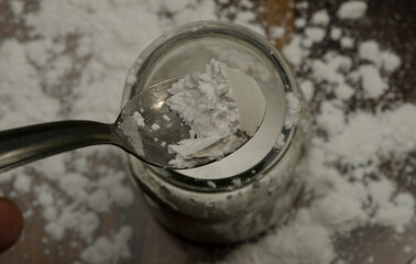 baking powder in spoon on wood