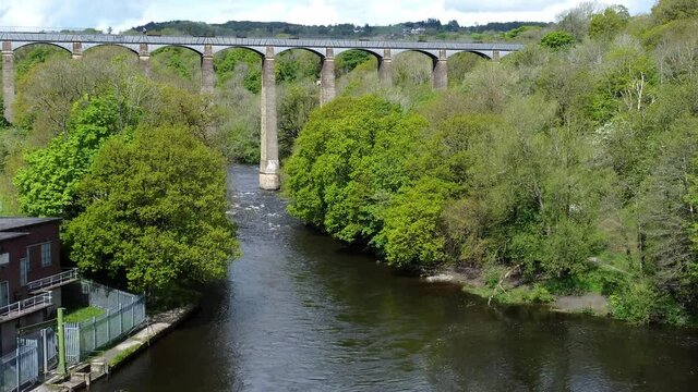 Aerial view Pontcysyllte aqueduct and River Dee canal narrow boat bride in Chirk Welsh valley countryside slow push in